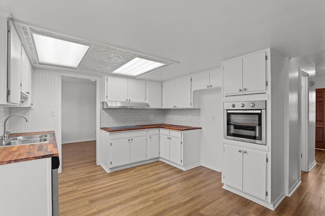 4004 Columbia Rd, Martinez, GA 30907 - kitchen featuring oven, a sink, under cabinet range hood, wooden counters, and light wood-style flooring