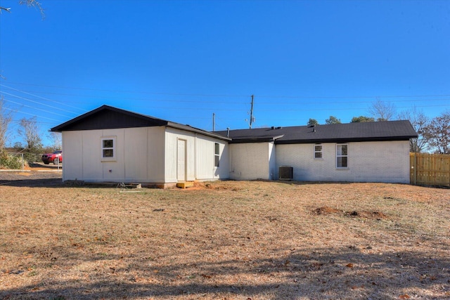 back of property featuring a yard, fence, cooling unit, and brick siding