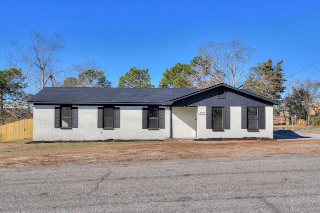 view of front of property with brick siding and fence