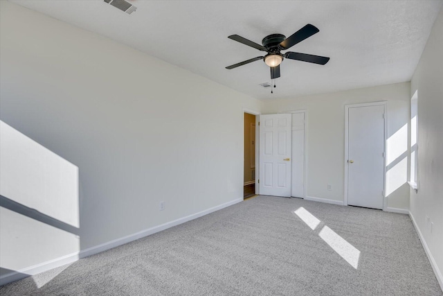 unfurnished bedroom featuring a ceiling fan, visible vents, baseboards, and carpet flooring