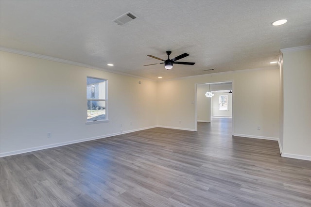 spare room featuring ceiling fan, a wealth of natural light, and visible vents