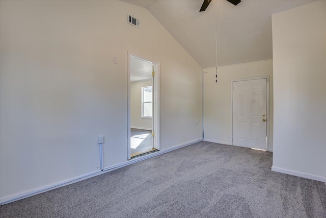 carpeted spare room featuring a ceiling fan, visible vents, vaulted ceiling, and baseboards