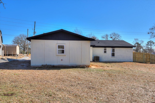 rear view of house with central AC and fence