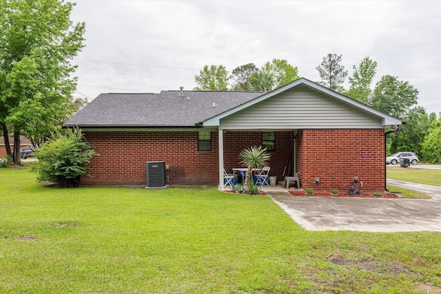 106 Allie Rd, Wrens, GA 30477 - back of house featuring brick siding, central AC, a lawn, roof with shingles, and a patio area