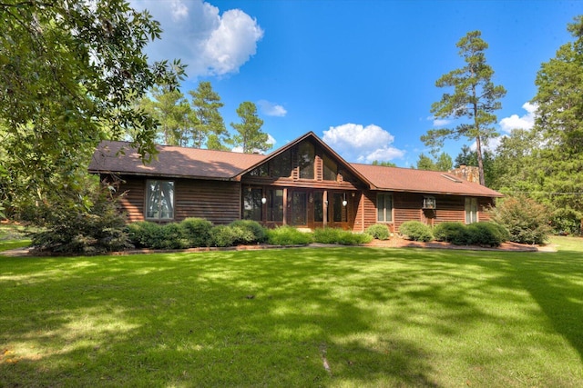 rear view of house featuring a lawn