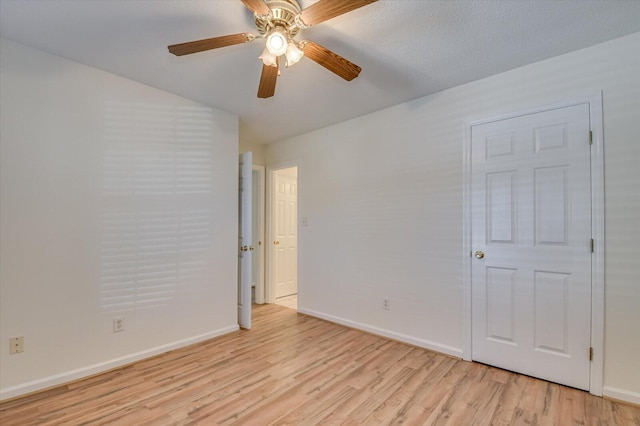 spare room with baseboards, a ceiling fan, and light wood-style floors