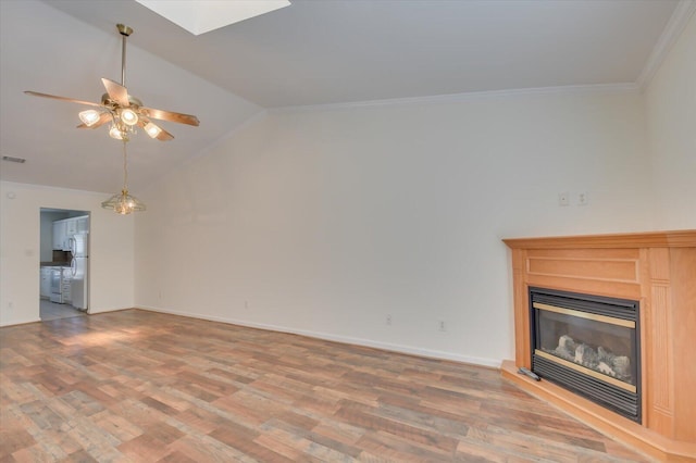 unfurnished living room with vaulted ceiling with skylight, baseboards, a glass covered fireplace, ceiling fan, and wood finished floors