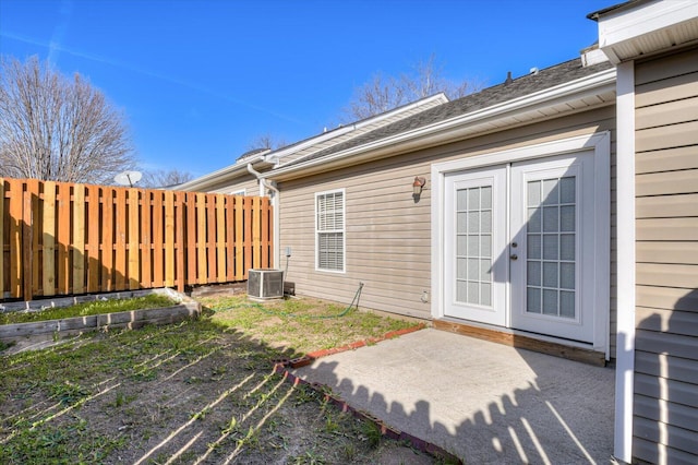 property entrance featuring cooling unit, french doors, a patio area, and fence