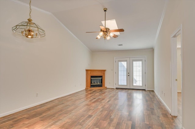 unfurnished living room featuring french doors, visible vents, ornamental molding, wood finished floors, and baseboards