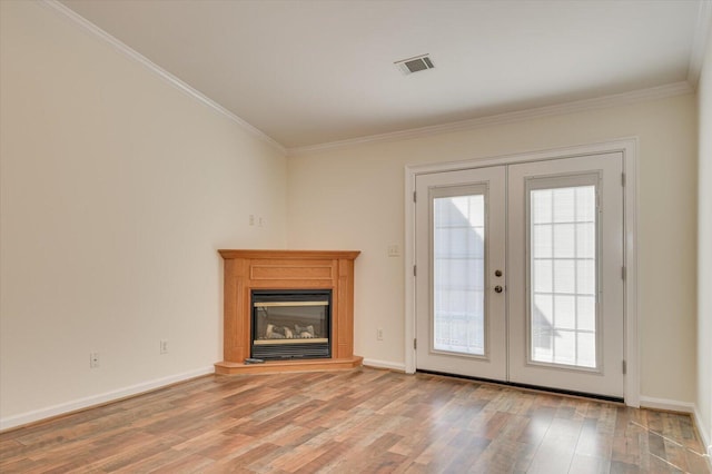 unfurnished living room with a wealth of natural light, french doors, visible vents, and light wood finished floors