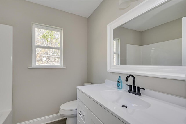 bathroom with vanity, toilet, and a shower