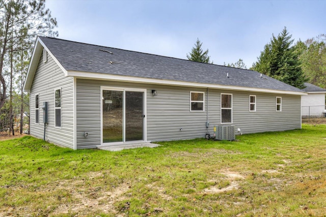 rear view of house with a yard and central AC unit