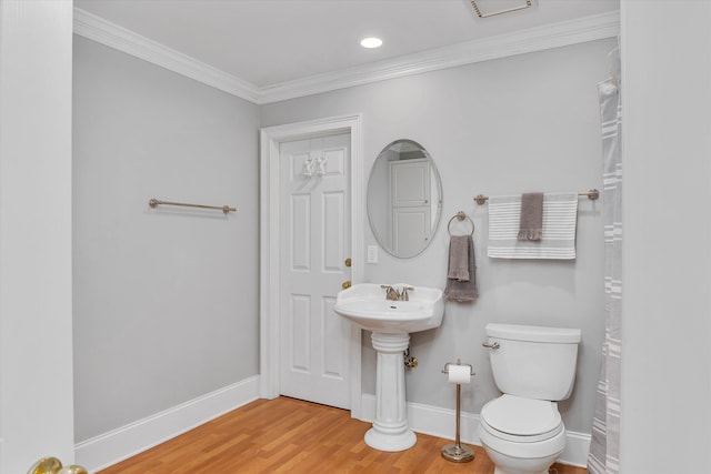 bathroom with toilet, wood-type flooring, and ornamental molding