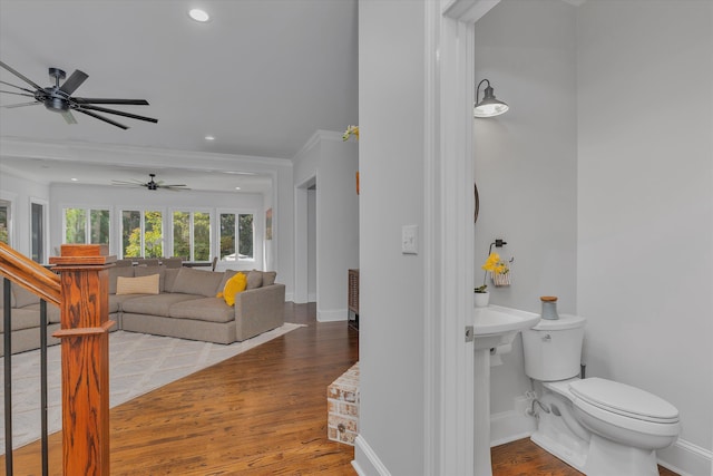 bathroom featuring hardwood / wood-style flooring, toilet, and ornamental molding