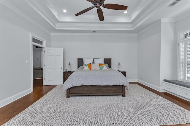 bedroom featuring a raised ceiling, ceiling fan, dark hardwood / wood-style flooring, and crown molding