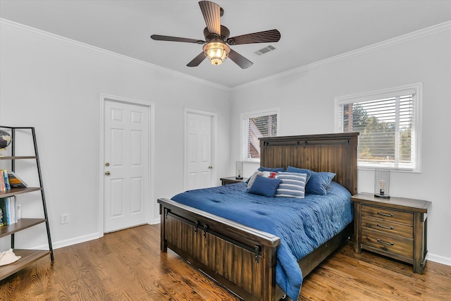 bedroom with hardwood / wood-style floors, ceiling fan, and crown molding