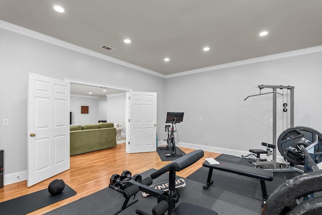 workout room featuring hardwood / wood-style floors and ornamental molding