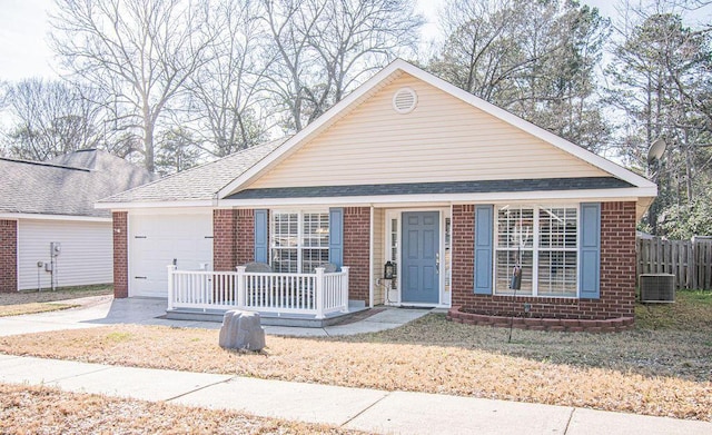 view of front facade with an attached garage, covered porch, brick siding, driveway, and roof with shingles