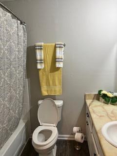 full bathroom featuring vanity, shower / bath combination with curtain, and toilet