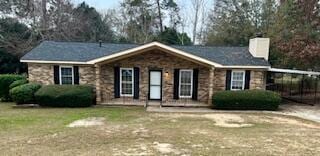 view of front of house with a carport and a front lawn