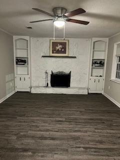 unfurnished living room with crown molding, built in features, and dark hardwood / wood-style floors