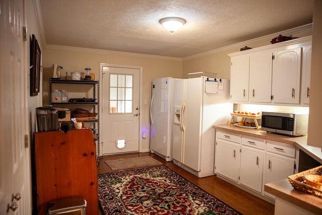 6287 Rousseau Creek Rd, Thomson, GA 30824 - kitchen with stainless steel microwave, white fridge with ice dispenser, crown molding, a textured ceiling, and white cabinets