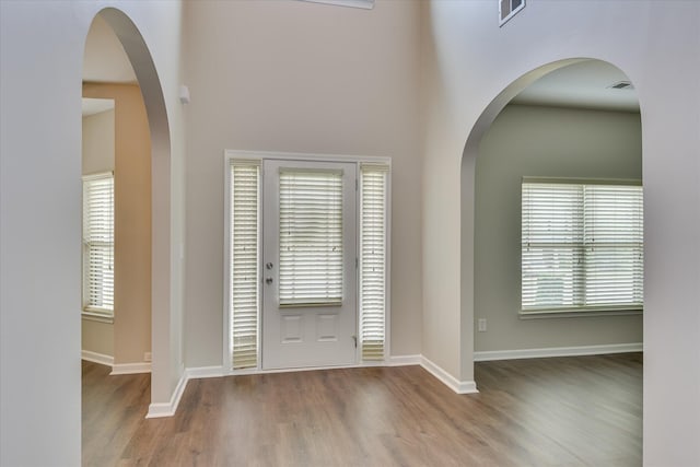 foyer entrance featuring visible vents, wood finished floors, and baseboards