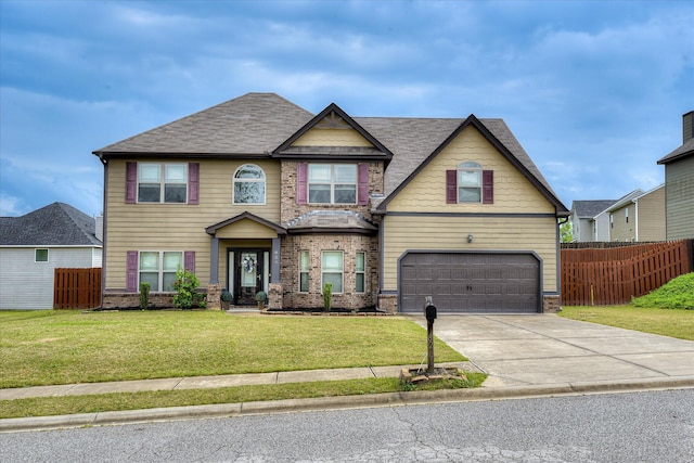 craftsman house featuring brick siding, fence, driveway, a front yard, and an attached garage