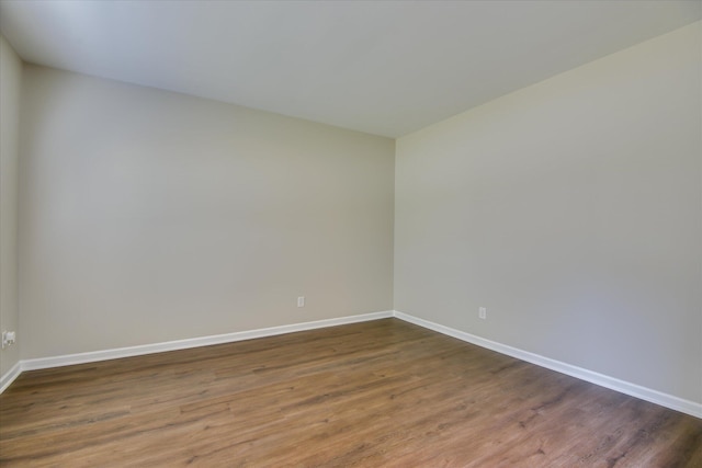 unfurnished room with wood finished floors and baseboards