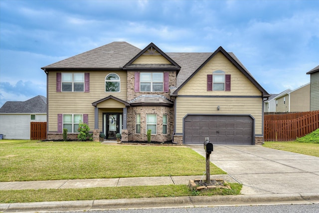 craftsman-style home with concrete driveway, a front yard, an attached garage, fence, and brick siding