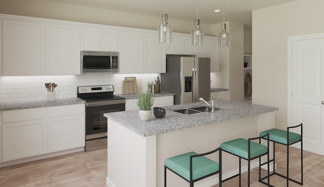 2027 Saylor Ln, Grovetown, GA 30813 - kitchen with stainless steel appliances, light wood-style flooring, an island with sink, backsplash, and a kitchen bar