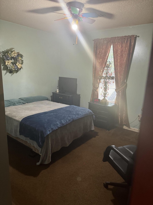 bedroom featuring ceiling fan, carpet floors, and a textured ceiling