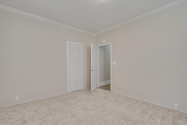 empty room featuring light carpet and crown molding