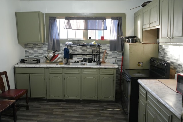 kitchen with tile counters, dark hardwood / wood-style flooring, tasteful backsplash, black electric range oven, and green cabinets