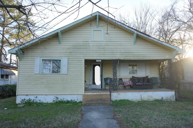 bungalow with a front lawn and covered porch