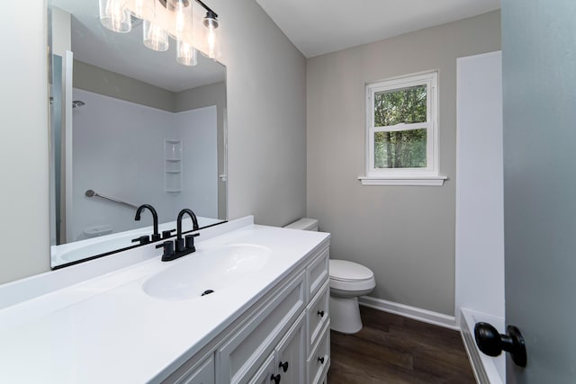 bathroom featuring wood-type flooring, vanity, and toilet