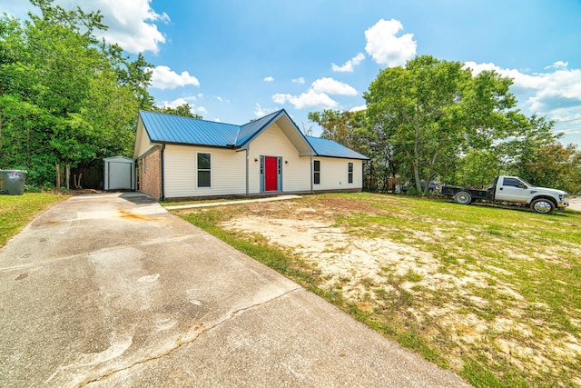 view of front facade featuring a front lawn and an outdoor structure