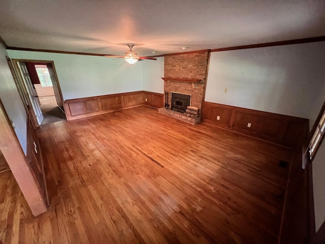 unfurnished living room featuring ceiling fan, ornamental molding, a textured ceiling, and hardwood / wood-style flooring