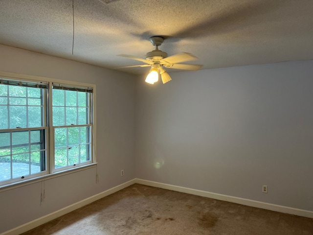 spare room featuring carpet flooring, ceiling fan, and a textured ceiling