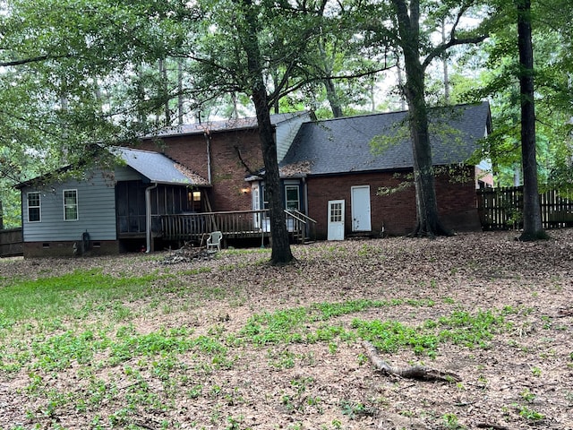 rear view of house featuring a sunroom and a deck