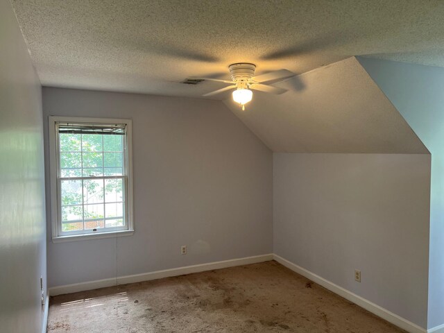 bonus room featuring carpet flooring, ceiling fan, a textured ceiling, and vaulted ceiling