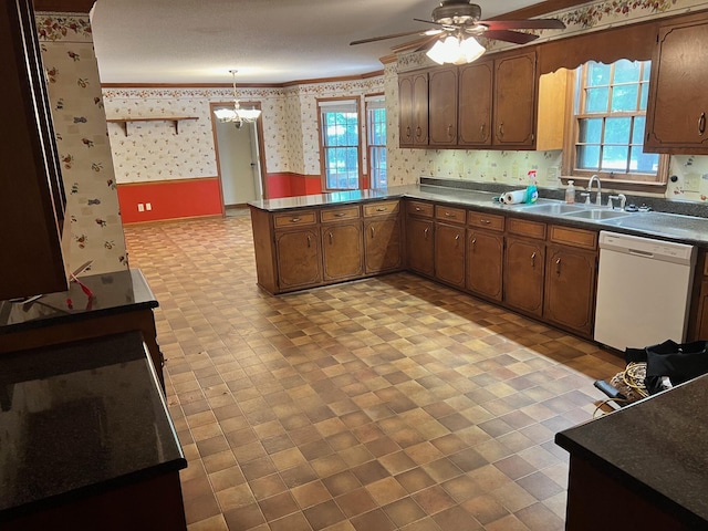 kitchen with sink, kitchen peninsula, white dishwasher, pendant lighting, and ceiling fan with notable chandelier