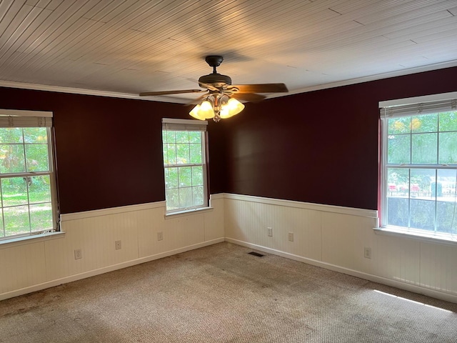 carpeted empty room with ceiling fan and ornamental molding