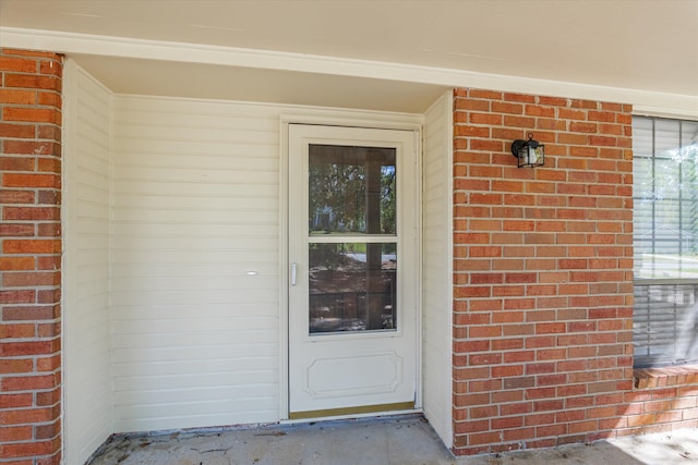 doorway to property featuring brick siding