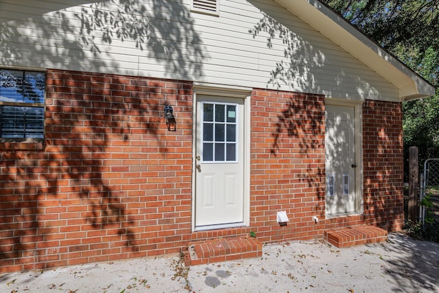 entrance to property featuring brick siding