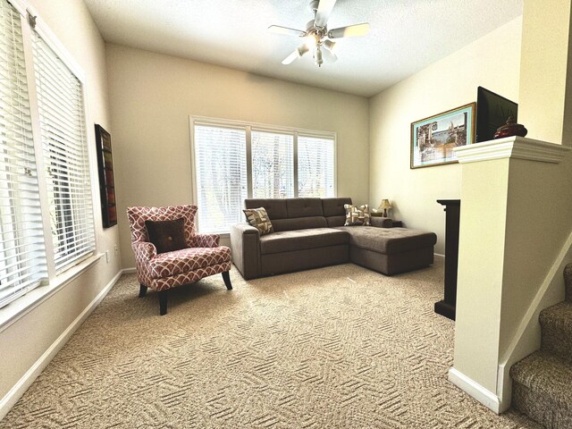 carpeted living room with ceiling fan