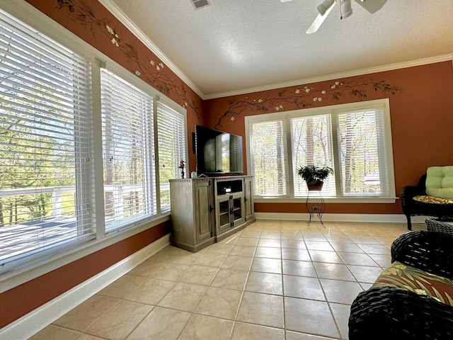 living room with ceiling fan, light tile patterned floors, a textured ceiling, and ornamental molding