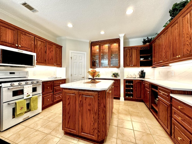 kitchen featuring range, a center island, a textured ceiling, and ornamental molding