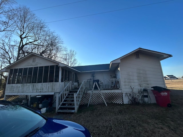 rear view of house featuring a sunroom