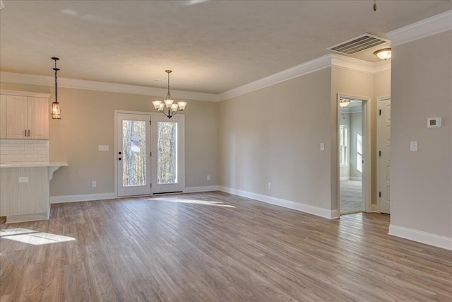 interior space with an inviting chandelier, crown molding, and light hardwood / wood-style flooring